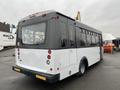 A 2018 Chevrolet Express bus with a white and black exterior featuring a large windowed body and red brake lights positioned at the rear