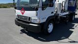 A 2006 Ford LCF 550 truck with a white body and hazard symbol on the front, designed for transporting materials