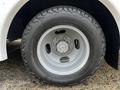 Close-up of a silver wheel and tire on a 2017 Chevrolet Express showcasing a rugged tread pattern and detailed hub assembly