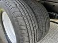 A close-up of a pair of tires from a 2013 Ford Econoline showing deep treads and white rims with visible wear patterns