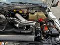 Close-up view of the engine compartment of a 2016 Ford F-550 featuring various components such as hoses and an engine cover