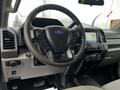 Interior view of a 2020 Ford F-350 SD featuring a steering wheel with controls a modern dashboard display and various knobs and buttons for vehicle functions