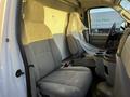Interior of a 2017 Ford Econoline van featuring two gray cloth front seats and a center console