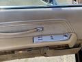 The interior door panel of a 1982 Mercury Grand Marquis featuring a light beige fabric and chrome trim with controls for the windows and locks