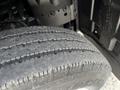 A close-up view of a worn tire from a 2004 Toyota Toyoace showing significant tread wear and visible cracks on the rubber surface