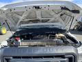 A 2013 Ford F-250 SD with its hood open revealing the engine compartment and various engine components including a radiator and battery