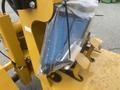 A blue and silver air filter encased in a clear plastic bag attached to a yellow mini loader