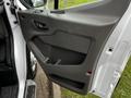 The interior door panel of a 2023 Ford Transit showing a sleek design with a handle and storage compartment
