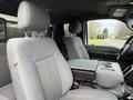 Interior view of a 2013 Ford F-350 SD showing gray fabric seats with a center console and cup holders