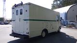 A white 2004 Freightliner MT45 delivery truck featuring a high roof and a rear roll-up door with side access panels