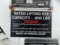 A close-up of a warning label on a 2013 International DuraStar indicating a rated lifting eye capacity of 800 lbs with safety instructions and a caution about serious injury