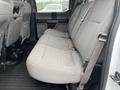 Interior view of the rear seat of a 2016 Ford F-150 with gray fabric upholstery and a seatbelt attached