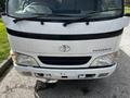 Front view of a 2004 Toyota Toyoace featuring a white exterior and signature Toyota emblem on the grille with headlights flanking the bumper