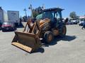 A 2008 Case Super 580M backhoe loader with a yellow exterior and a front bucket attachment positioned in a parking area