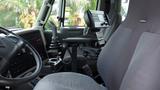 Interior view of a 2014 International 7500 truck showcasing the driver's seat control panel and gear shifter