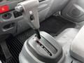 Close-up of the gear shift lever in a 2018 Isuzu NRR truck featuring a silver and black design with gear indicators for reverse neutral and drive