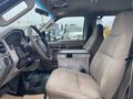 Interior of a 2009 Ford F-450 SD with a cloth seat a steering wheel and a metal box on the passenger side