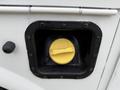 A yellow fuel cap inside a black rimmed fuel access door on a 2013 Ford F-350 SD