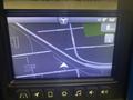 A digital touchscreen display showing a GPS navigation interface with a map and direction indicators