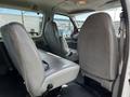 Interior view of a 2004 Ford Econoline showcasing two front seats and two rear captain's chairs with gray upholstery