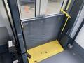 A yellow floor of a lift platform with a metal mesh barrier and mechanical controls visible on the side in a Chevrolet Express van