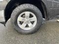 A close-up view of a 2015 RAM 1500 wheel featuring a silver alloy rim and a rugged all-terrain tire with deep treads