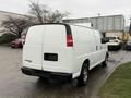 A white 2009 Chevrolet Express cargo van viewed from the rear with no visible license plate and large rear doors