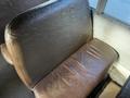 A brown leather bus seat inside a vintage 2005 Blue Bird 48 passenger bus