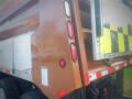 A 2016 International WorkStar 7500 truck with a large brown and yellow body featuring tail lights and a storage compartment on the side