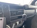 Interior dashboard of a 2014 Chevrolet Express with air vents a radio control panel and a black finish