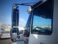 A 2011 International DuraStar 4300 truck with a large side mirror and a partial view of the windshield and driver cockpit