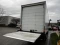 A 2018 Freightliner M2 106 truck with a large white cargo box and a lowered rear loading ramp