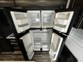 An open refrigerator with four doors showcasing empty shelves and compartments inside