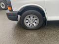 A close-up of a wheel from a 2012 Chevrolet Express showing a chrome rim and a black tire with visible tread marks